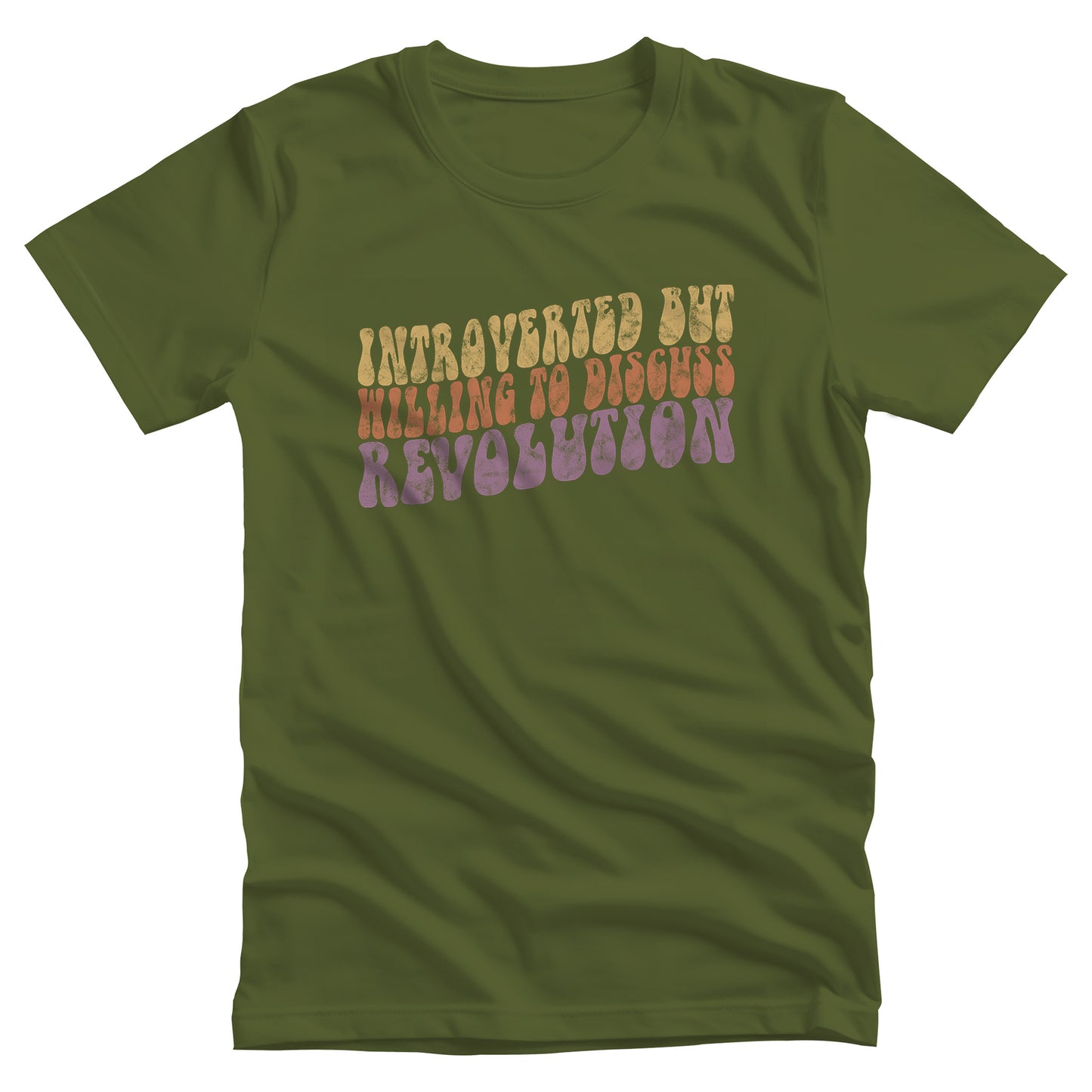 Olive color unisex t-shirt with a vintage graphic on it that looks worn and grungy. The graphic says “Introverted but willing to discuss revolution” in a retro font in all caps. Each line is a different color: “Introverted but” is a retro yellow, “willing to discuss” is a retro red, and “Revolution” is a retro purple. The graphic is a wavy shape and slopes upwards to the right.