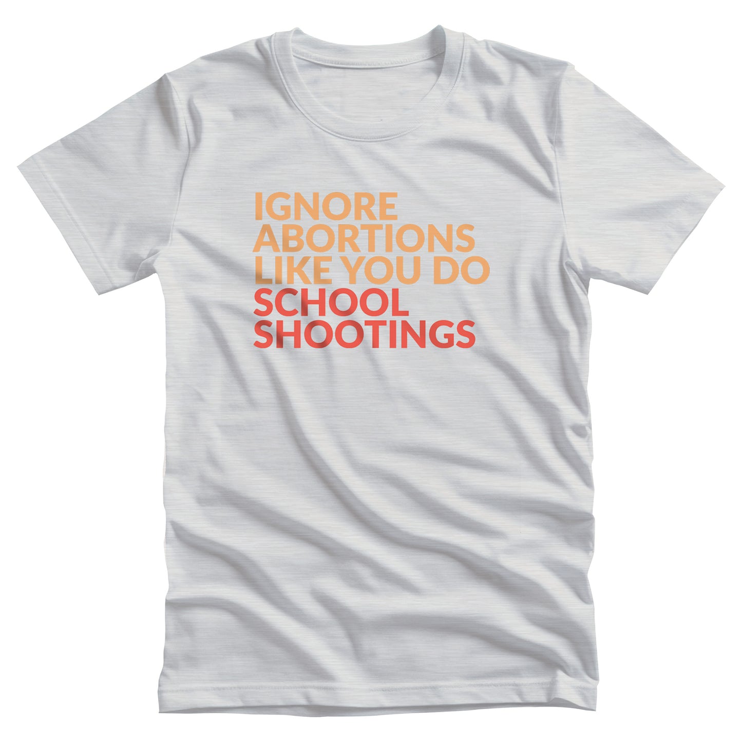 Ash color unisex t-shirt that says “Ignore abortions like you do school shootings” in all caps. “Ignore abortions like you do” is orange and “school shootings” is red.