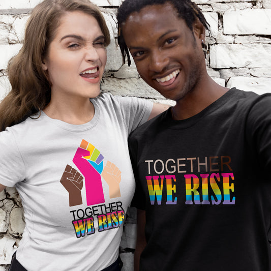 A white woman and a Black man wearing shirts that say "Together We Rise." Each shirt represents LGBTQ+ people, Black people, and white people rising together.