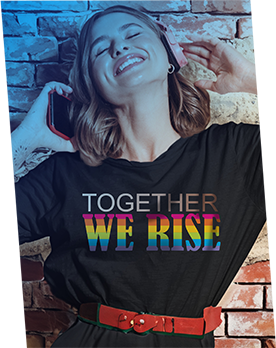 A woman wearing a shirt that says "TOGETHER WE RISE." The word "TOGETHER" is in a skin-tone gradient from white skin tone to dark brown skin tone. "WE RISE" is in horizontal rainbow colors.
