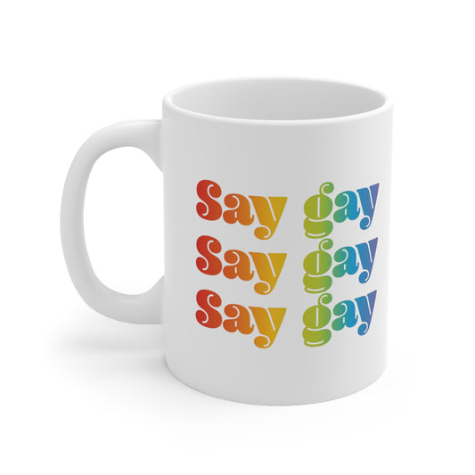 11oz white ceramic mug that reads “Say gay” x3 rows in a thick, rainbow font.