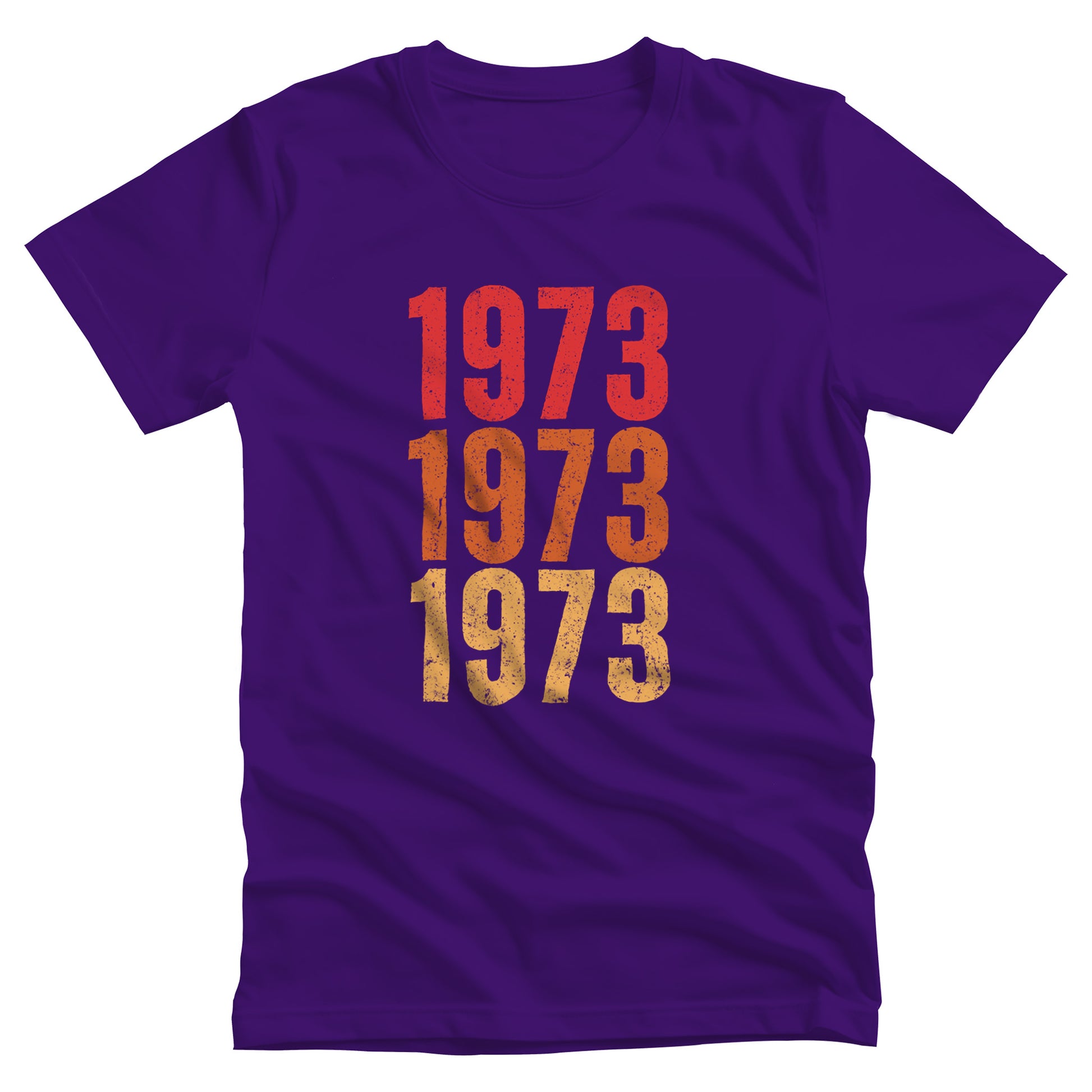 Team Purple color vintage-style unisex t-shirt with ‘1973” on the front, featuring retro-inspired colors and slight distressing, repeated three times in distinct rows.