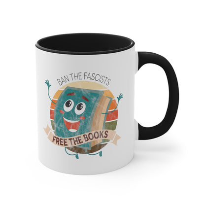 Mug with a black handle and interior with a graphic that says “Ban the Fascists, Free the Books” with a vintage illustration of a cartoon book leaping for joy. There is a circle of vintage-colored stripes behind it. 