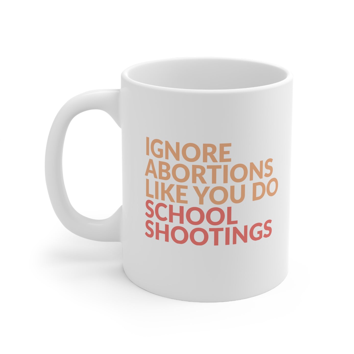 White 11oz ceramic mug that says “Ignore abortions like you do school shootings” in all caps in an orange font. The words “school shootings” are in red. The handle is on the left side in this image.