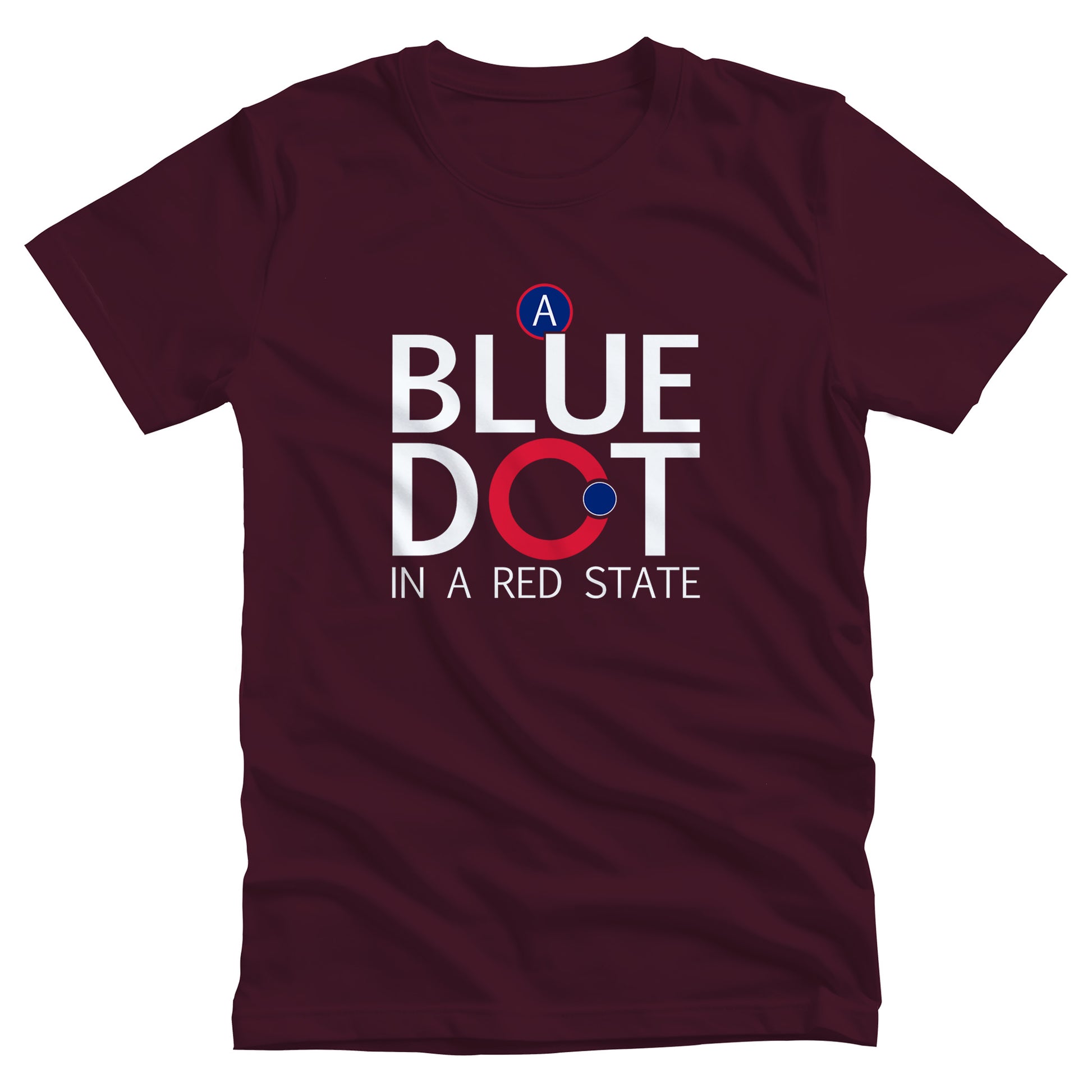 Maroon unisex t-shirt that says, “A Blue Dot in a Red State” in all caps. “A Blue Dot” are all on their own line, and “A Red State” is on its own line. The “O” in “Dot” is red with a small blue dot on the outer edge