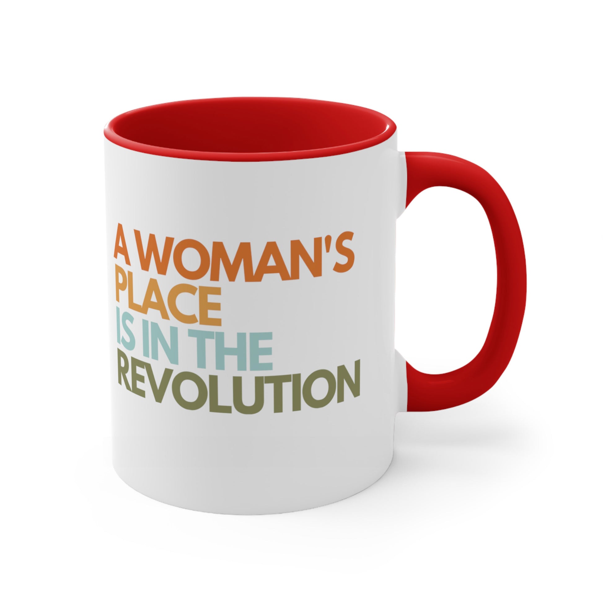 11oz ceramic mug with a red interior and handle that says “A woman’s place is in the revolution” in a round, modern font in all caps and left aligned. Each line is a different color. “A Woman’s” is orange, “place” is yellow-orange, “is in the” is light blue, and “revolution” is military green.