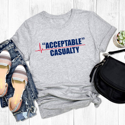 Athletic Heather color unisex t-shirt that says, “Acceptable” Casualty with each word on its own line. There is a red heartbeat graphic to the left of the text with a straight, flat line extending out between the two words.