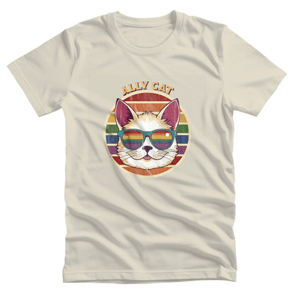 Natural color unisex t-shirt with a circular retro-inspired image of a cat wearing rainbow sunglasses with a retro sunset made from parallel lines behind it. The text reads “ALLY CAT” in all caps, arched over the image. The graphic has a retro, worn texture.