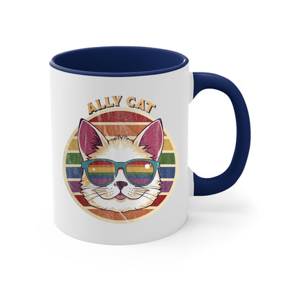 11oz ceramic mug with a navy blue handle and interior with a circular retro-inspired image of a cat wearing rainbow sunglasses with a retro sunset made from parallel lines behind it. The text reads “ALLY CAT” in all caps, arched over the image. The graphic has a retro, worn texture.