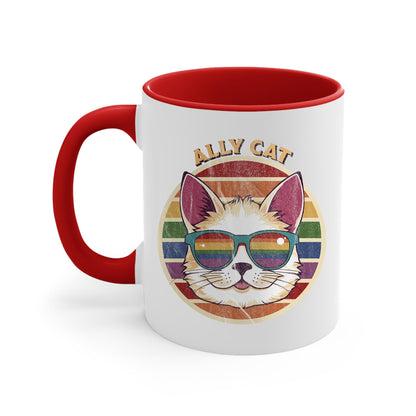 11oz ceramic mug with a red handle and interior with a circular retro-inspired image of a cat wearing rainbow sunglasses with a retro sunset made from parallel lines behind it. The text reads “ALLY CAT” in all caps, arched over the image. The graphic has a retro, worn texture.