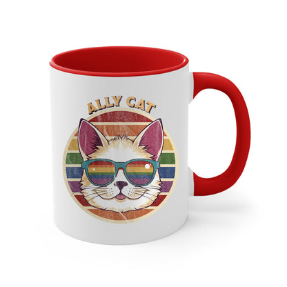 11oz ceramic mug with a red handle and interior with a circular retro-inspired image of a cat wearing rainbow sunglasses with a retro sunset made from parallel lines behind it. The text reads “ALLY CAT” in all caps, arched over the image. The graphic has a retro, worn texture.