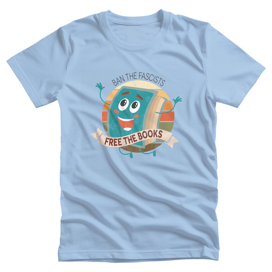 Baby Blue color unisex t-shirt with a graphic that says “Ban the Fascists, Free the Books” with a vintage illustration of a cartoon book leaping for joy. There is a circle of vintage-colored stripes behind it.