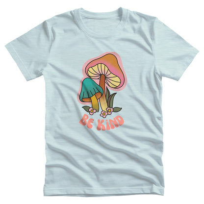 Heather Ice Blue color unisex t-shirt that says “Be Kind” in a retro font with two retro mushrooms above the text. The text is slightly arched down.