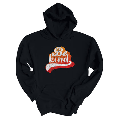 Black hoodie that says, “Be Kind” in a script font that is an orange gradient color. The “d” has a unique swoosh glyph extending below the word, adding a dynamic and flowing aesthetic to the text.