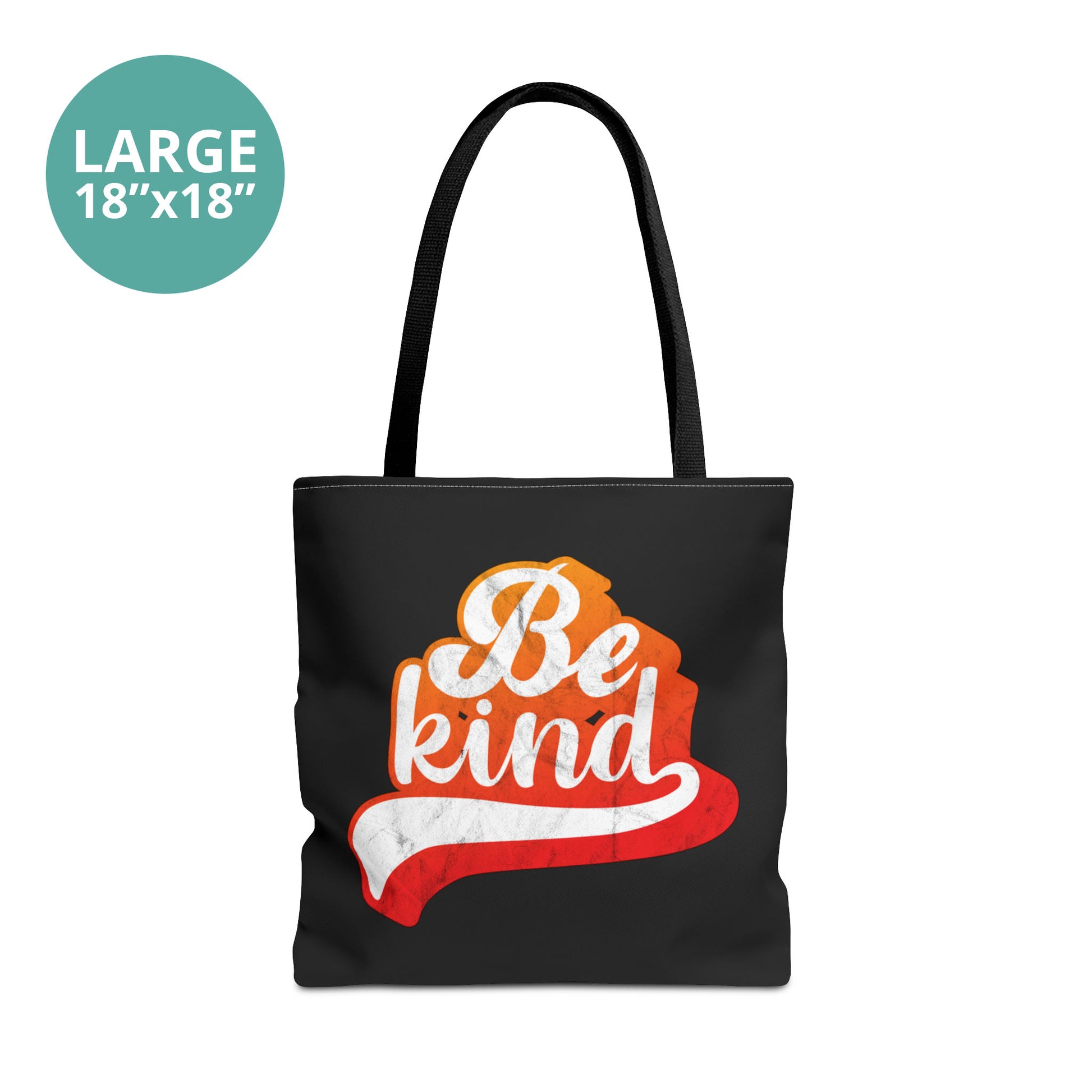 Large 18x18” black tote bag that says, “Be Kind” in a script font that has an orange gradient. The “d” has a unique swoosh glyph extending below the word, adding a dynamic and flowing aesthetic to the text.