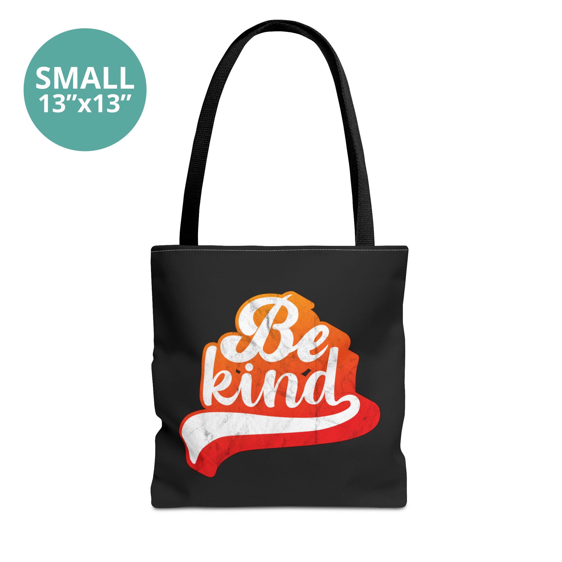 Small 13x13” black tote bag that says, “Be Kind” in a script font that is an orange gradient color. The “d” has a unique swoosh glyph extending below the word, adding a dynamic and flowing aesthetic to the text.