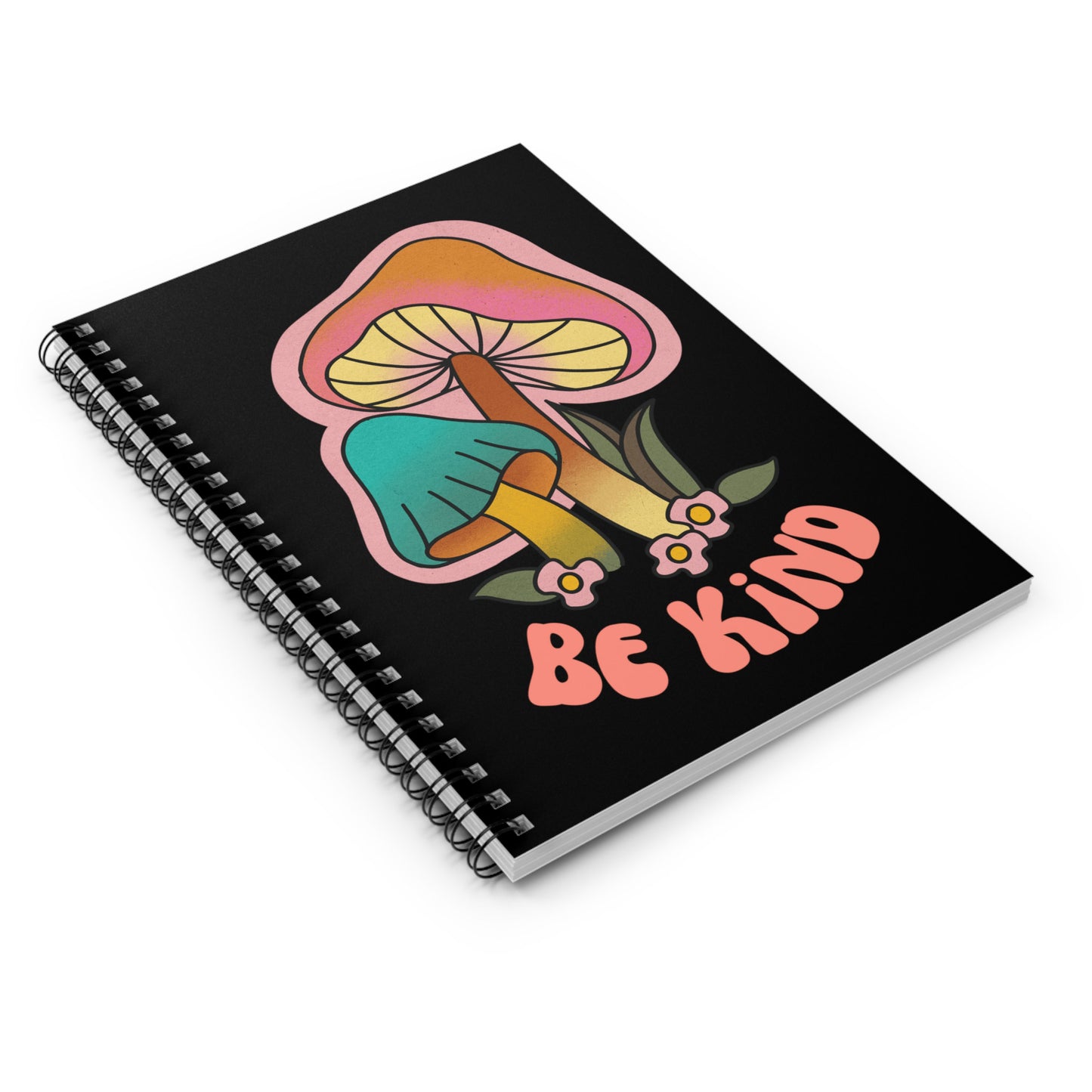 Black spiral notebook that says “Be Kind” on the front in a retro font with two retro mushrooms above the text. The text is slightly arched down.