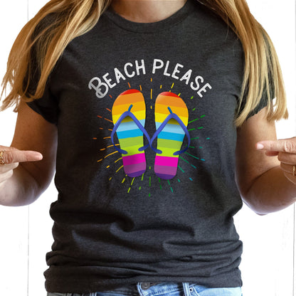 Dark Grey Heather color unisex t-shirt that says, “BEACH PLEASE” arched over a graphic of rainbow-colored flip flops with a rainbow gradient starburst behind it.