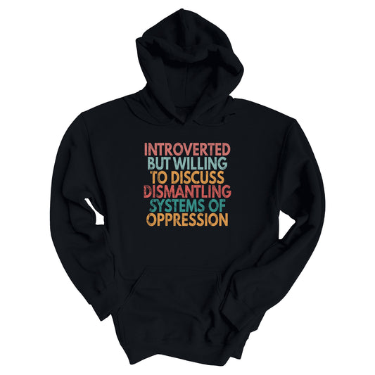 Black unisex hoodie with a graphic that says “Introverted but willing to discuss dismantling systems of oppression.” The graphic is slightly distressed, and each line of the graphic is a different color.