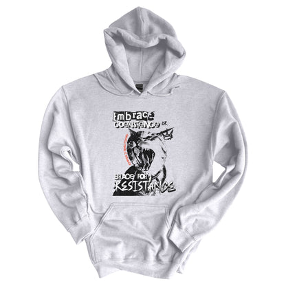 Ash color hoodie featuring the phrase 'Embrace Coexistence or Brace for Resistance' in a grunge font. The shirt includes an illustration of a cat meowing loudly with a small crown to the right, adding to the grunge aesthetic. Small red letters along the left side of the cat's face, written vertically say, ‘Kindness is revolutionary' in all caps.