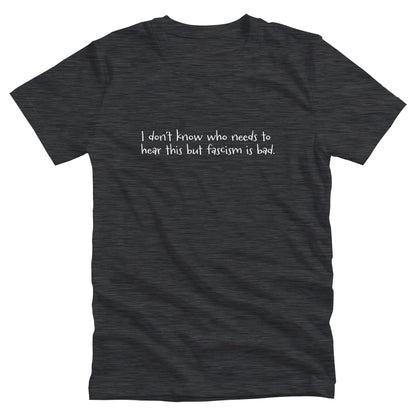 Dark Grey Heather color unisex t-shirt that reads in a hand-written font, “I don’t know who needs to hear this but fascism is bad.” It takes up two lines.