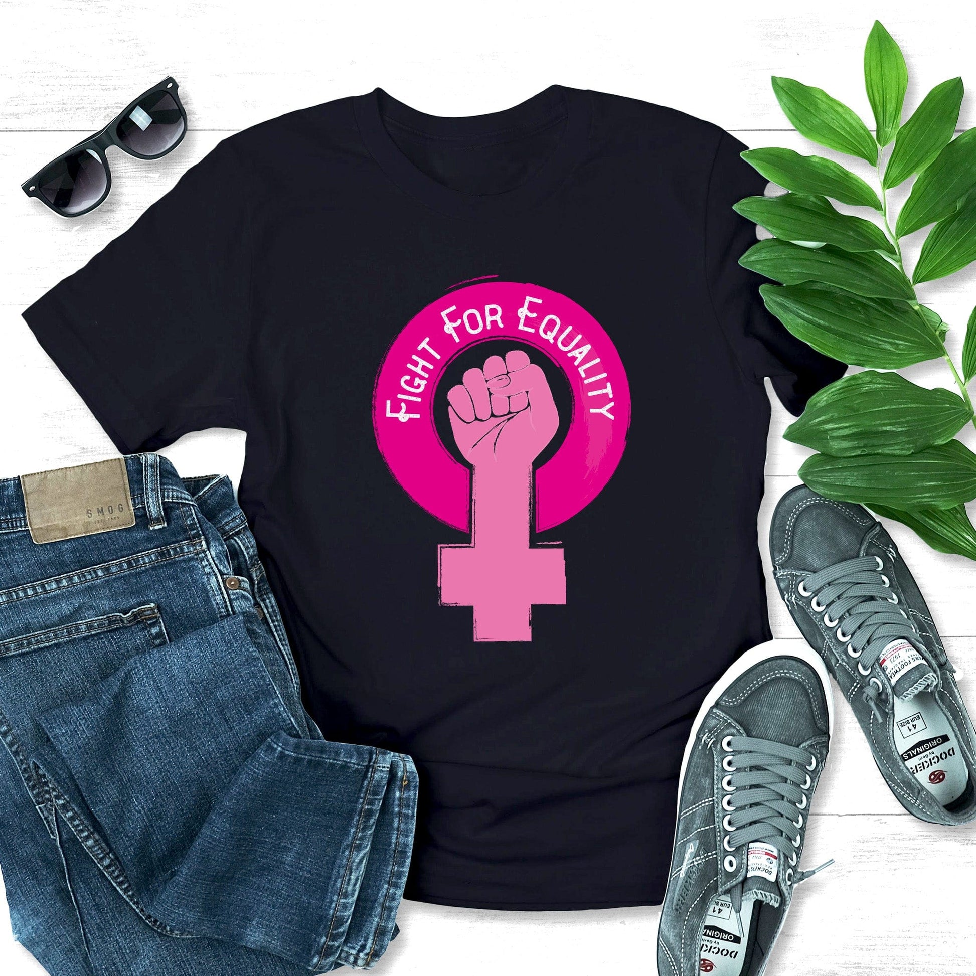 Black unisex t-shirt that says, “Fight for Equality” arched inside a pink gender symbol for women. The “T” in the symbol is in the shape of a fist.