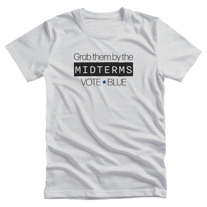 Ash color unisex t-shirt that say, “Grab them by the midterms. Vote Blue.” The word “Midterms” is in a black rectangle. 