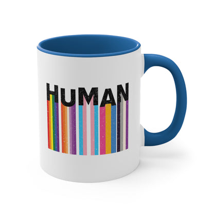 11oz ceramic mug with a blue interior and handle. It has a colorful and dynamic image featuring the word "HUMAN" written in an artistic style.  Each letter is arranged to create a wavy pattern. There are stripes of colors coming down from the bottom of each letter representing different sexualities in the LGBTQ+ community. The "H" represents Gay, the "U" represents Lesbian, the "M" represents Trans, the "A" represents Pansexual, and the "N" represents Asexual.