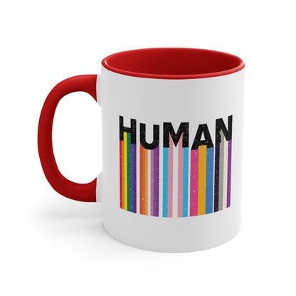 11oz ceramic mug with a red interior and handle. It has a colorful and dynamic image featuring the word "HUMAN" written in an artistic style.  Each letter is arranged to create a wavy pattern. There are stripes of colors coming down from the bottom of each letter representing different sexualities in the LGBTQ+ community. The "H" represents Gay, the "U" represents Lesbian, the "M" represents Trans, the "A" represents Pansexual, and the "N" represents Asexual.