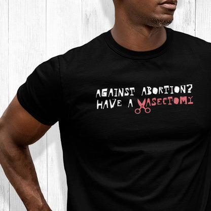 Black unisex t-shirt that says, “Against Abortion? Have a Vasectomy” in all caps. The word “Vasectomy” is red and the “V” is scissors.