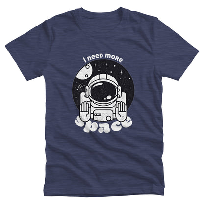 Heather Navy color unisex t-shirt that says, “I need more space”. The text is a retro font. There is a graphic of an astronaut inside a circle with their hands in the stop position. “I need more” is arched over the graphic, and “space” is reverse-arched over the bottom of the graphic.