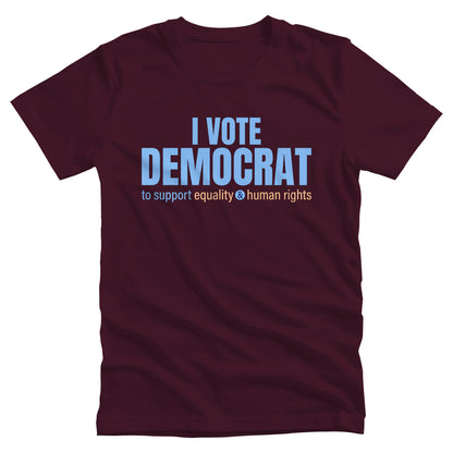 Maroon color unisex t-shirt that says, “I VOTE DEMOCRAT” in large blue letters. Beneath that on one line, it says, “to support equality & human rights”