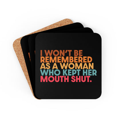 Four 3.75” x 3.75” black square coasters that say, “I won’t be remembered as a woman who kept her mouth shut” in all caps. The phrase is on 5 lines, with each line being a different color. “I won’t be” is brown, “remembered” is orange, “as a woman” is yellow-orange, “who kept her” is blue-green, and “mouth shut” is pink-red. 