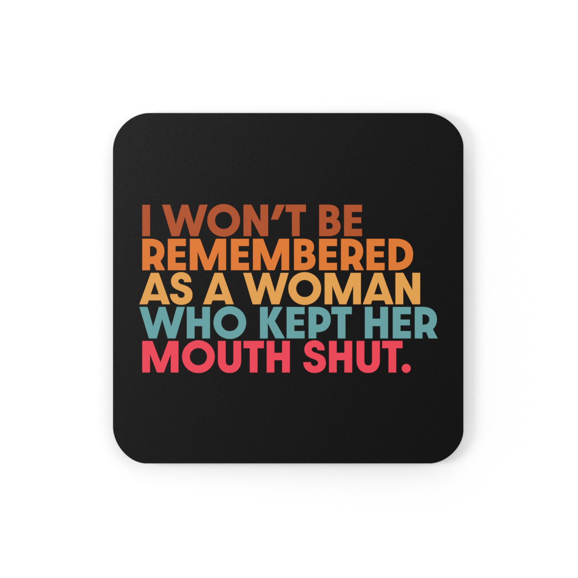 3.75” x 3.75” black square coaster that says, “I won’t be remembered as a woman who kept her mouth shut” in all caps. The phrase is on 5 lines, with each line being a different color. “I won’t be” is brown, “remembered” is orange, “as a woman” is yellow-orange, “who kept her” is blue-green, and “mouth shut” is pink-red. 