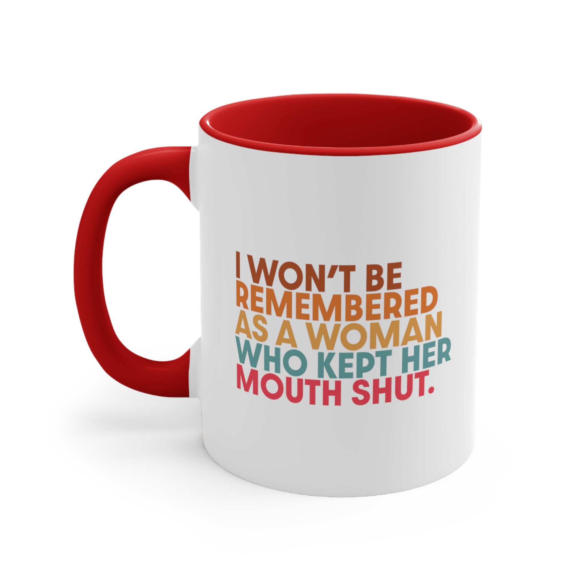 11oz ceramic mug with a red handle and interior that says, “I won’t be remembered as a woman who kept her mouth shut” in all caps. The phrase is on 5 lines, with each line being a different color. “I won’t be” is brown, “remembered” is orange, “as a woman” is yellow-orange, “who kept her” is blue-green, and “mouth shut” is pink-red. 