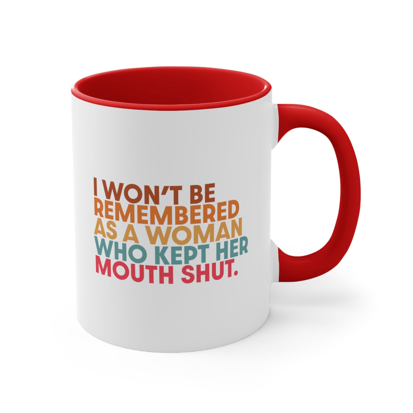 11oz ceramic mug with a red handle and interior that says, “I won’t be remembered as a woman who kept her mouth shut” in all caps. The phrase is on 5 lines, with each line being a different color. “I won’t be” is brown, “remembered” is orange, “as a woman” is yellow-orange, “who kept her” is blue-green, and “mouth shut” is pink-red. 