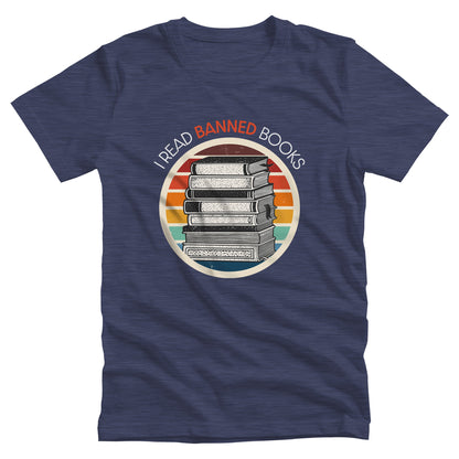 Heather Navy color unisex t-shirt with a circular graphic of stacked old books with a vintage sunset made from horizontal lines behind it. “I READ BANNED BOOKS” is arched over the graphic with the word. “BANNED” an orange color.