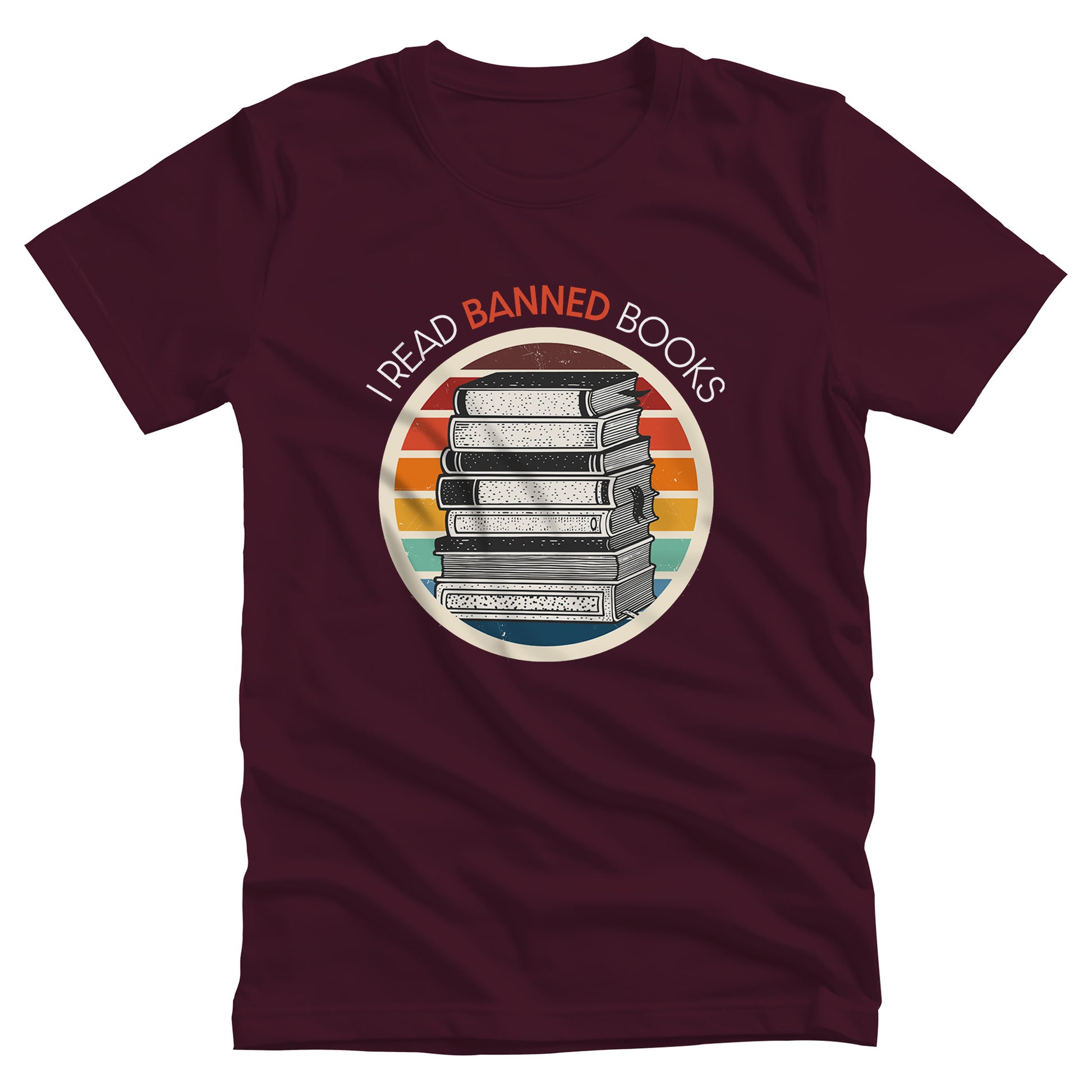 Maroon unisex t-shirt with a circular graphic of stacked old books with a vintage sunset made from horizontal lines behind it. “I READ BANNED BOOKS” is arched over the graphic with the word. “BANNED” an orange color.