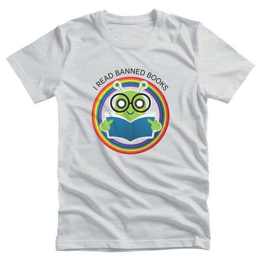 Ash color unisex t-shirt with a graphic of a bookworm with large eyeglasses reading a book. The bookworm is subtly holding up its middle fingers. The image is inside a circle that has rainbow colors. Arched over the top of the graphic are the words “I READ BANNED BOOKS.”