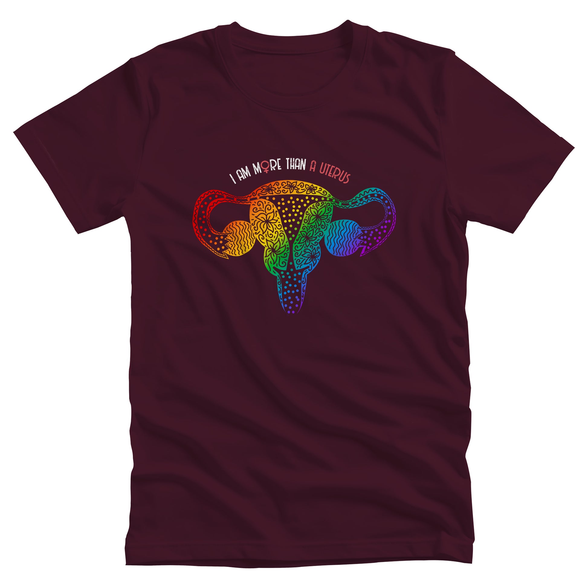 Maroon unisex t-shirt that says, “I am More Than a Uterus” in all caps. The “O” in “more” is the symbol for the female gender. The text is arched slightly over an illustration of a uterus made from swirls and flowers in a rainbow-gradient color.