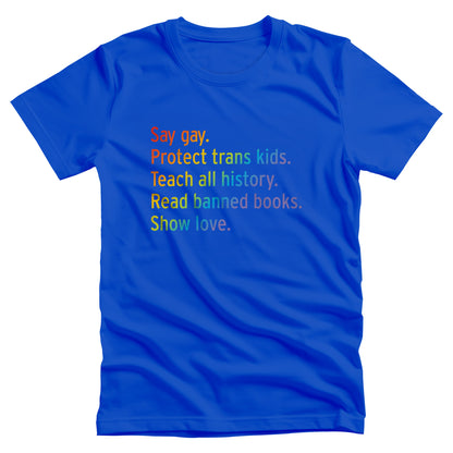 True Royal color unisex tank top with text that says “Say gay. Protect Trans Kids. Teach all history. Read banned books. Show love.” Each sentence is on its own line, and the entire graphic is colored with a rainbow gradient.