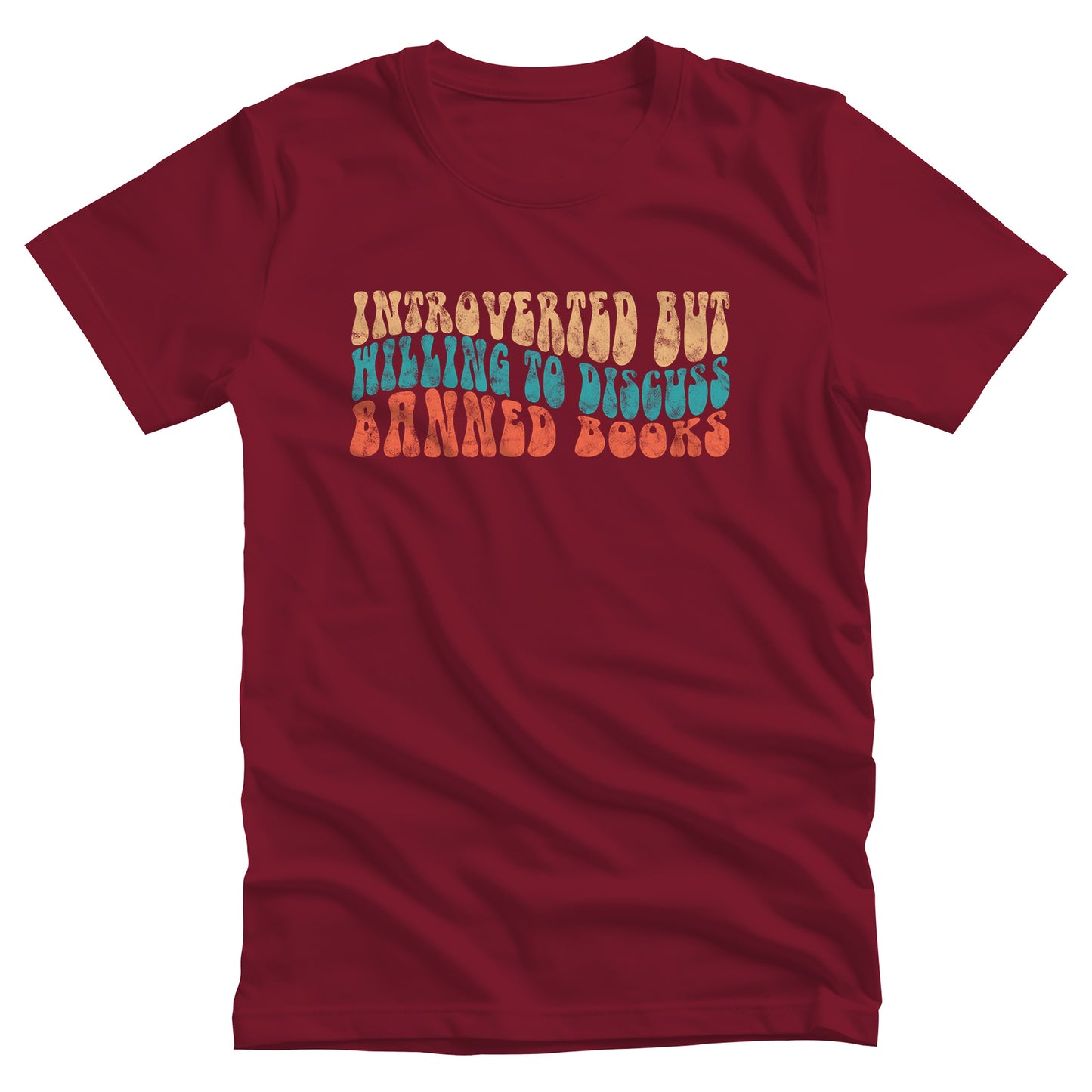 Cardinal color unisex t-shirt with a graphic that says “Introverted but willing to discuss banned books” in a retro, 1970s bubble font. Each line is a different color. The graphic is slightly distressed.