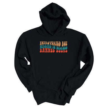 Black unisex hoodie with a graphic that says “Introverted but willing to discuss banned books” in a retro, 1970s bubble font. Each line is a different color. The graphic is slightly distressed.