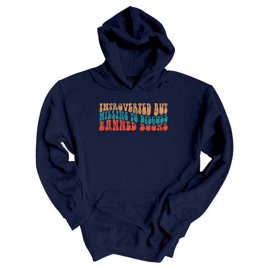 Navy Blue unisex hoodie with a graphic that says “Introverted but willing to discuss banned books” in a retro, 1970s bubble font. Each line is a different color. The graphic is slightly distressed.