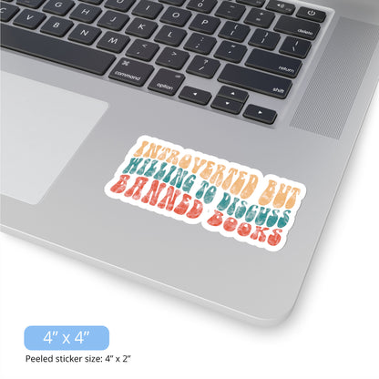 Contextual photo of the 4x4 inch (6x2.6” peeled) kiss-cut sticker that says “Introverted but willing to discuss banned books” in a retro, 1970s bubble font. Each line is a different color. The graphic is slightly distressed.