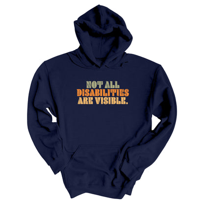 Navy Blue hoodie that says, “Not all disabilities are visible” in a thick, retro font in all caps. Each line is a different color. “Not all” is light green, “disabilities” is orange, and “are visible” is yellow. The graphic has a retro look and is slightly distressed.