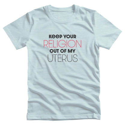 Heather Ice Blue color unisex t-shirt that says, “Keep Your Religion Out of My Uterus” in all caps. “Keep Your” is bold, “Religion” is on the next line, is a larger size, and is red, “out of my” is beneath that and in bold, and “uterus” is on the last line.