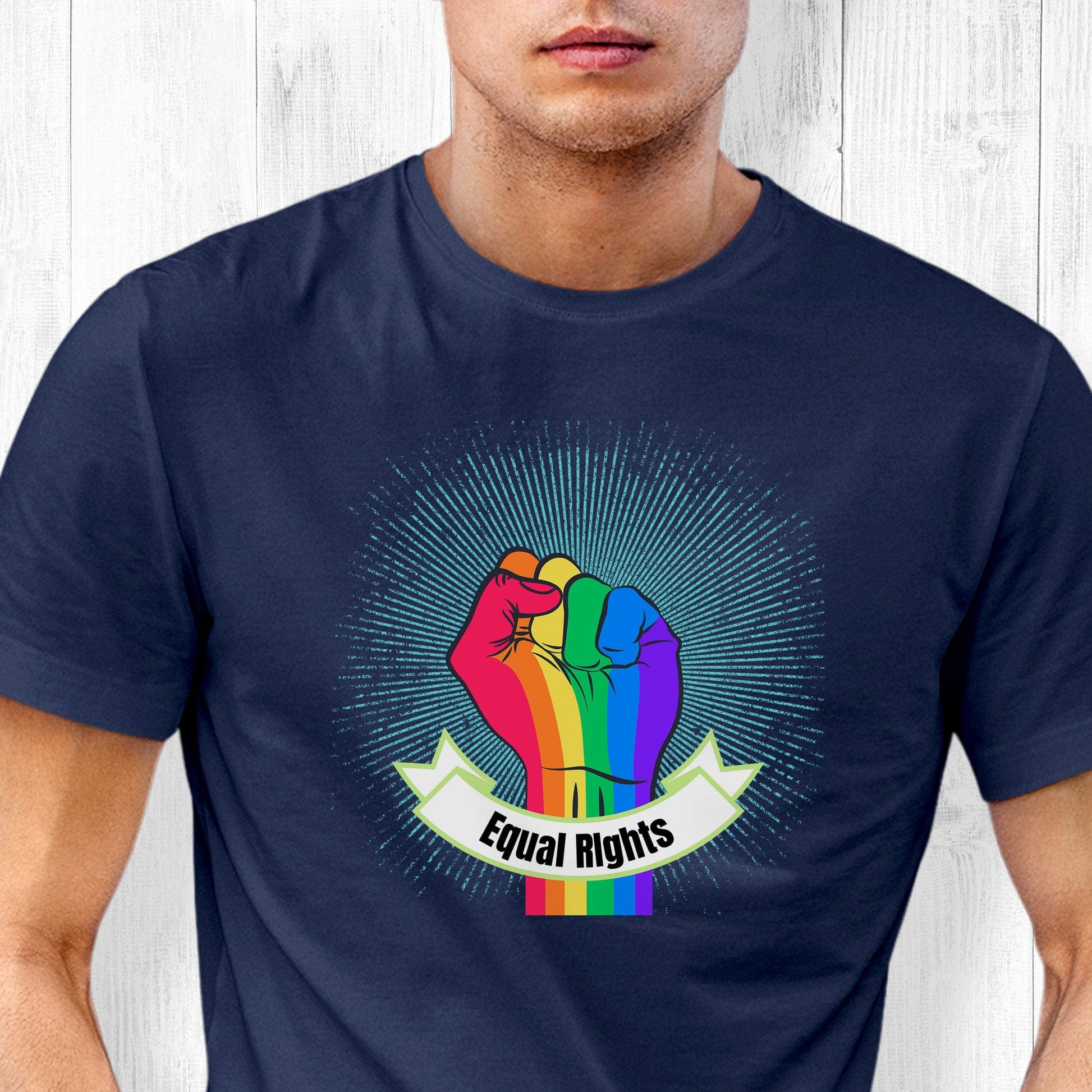 Navy Blue unisex t-shirt with a blue-green starburst and a rainbow fist in front of it. In a ribbon on the bottom of the fist over the wrist area, it says, “Equal Rights.”