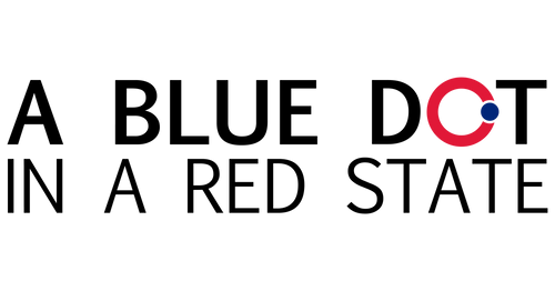 A Blue Dot in a Red Stage logo in text. The "O" is red with a blue dot at the 3 o'clock position on top of the "O."