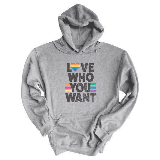 Sport Grey color hoodie says, “Love who you want” in all caps. Each word is on its own line. The “O” in “love” is a rainbow heart.